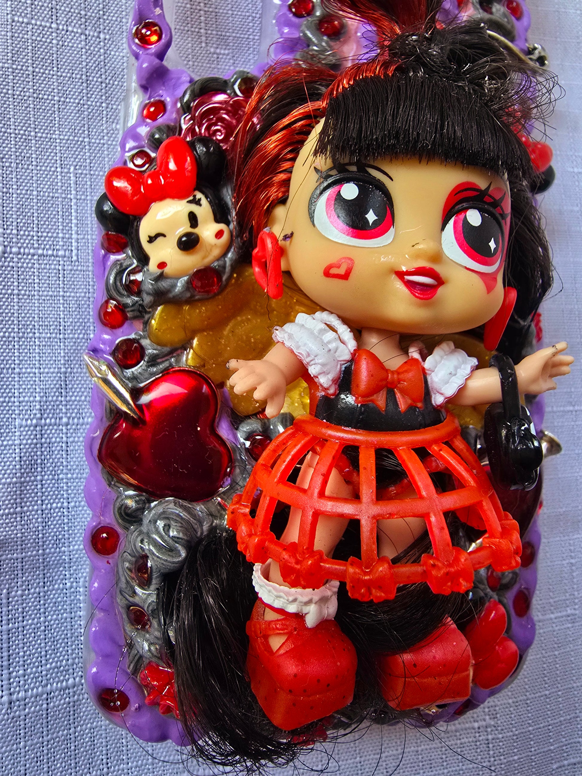 Handmade Samsung S23 Plus phone case with gothic and doll-inspired design, featuring red and black accents, heart charms, and 3D figure on a purple base.